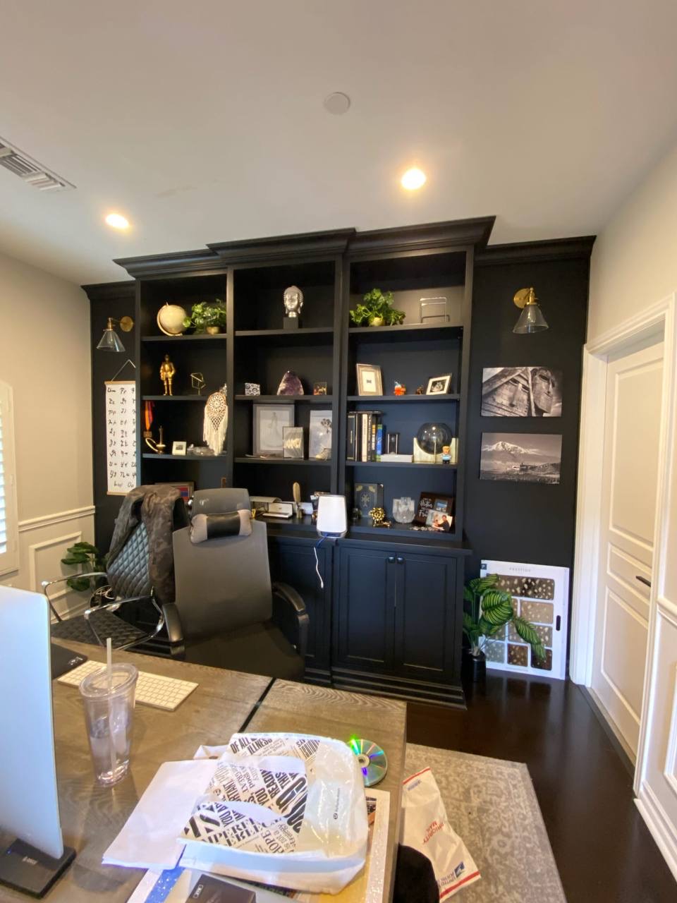 Custom black home office built-in bookcase with wall sconces and a desk return, installed in a Glendale CA home